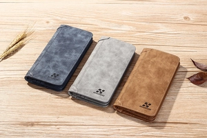 Détails de portefeuilles longs en cuir mat bleu, gris et marron sur une table en bois
