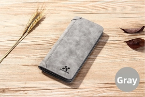 Gros plan sur un portefeuille long gris-blanc mat avec coutures et texture fine