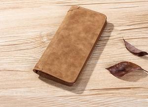 Vue détaillée d'un long portefeuille marron en cuir mat sur un fond en bois rustique