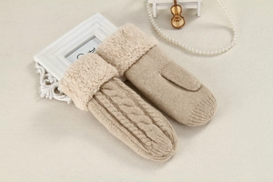 Detail of beige cable knit mittens with plush cuffs and elegant vintage props
