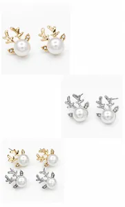 Gros plan de boucles d'oreilles bois de cerf avec perles en finitions or et argent