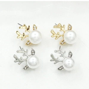 Détail de boucles d'oreilles renne élégantes en or et argent avec perles blanches et cristaux