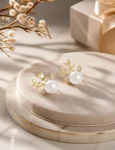 Détail de boucles d'oreilles bois de renne avec perles blanches et pierres en zircon