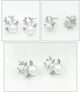 Détail de boucles d'oreilles renne argentées avec perle et éclats de cristal brillants