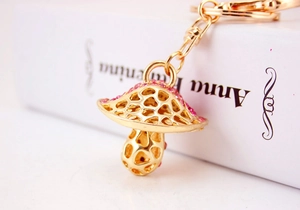 Close-up of golden mushroom keychain with pink crystal rhinestones and hollow design