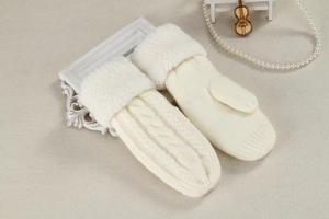 Warm white knitted mittens with plush cuffs displayed on an elegant decorative tabletop