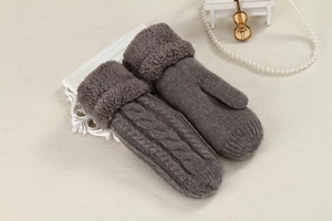 Close-up of grey knit mittens with cable pattern and thick plush faux fur cuffs