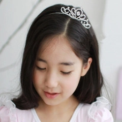 Close-up of a sparkling silver bridal crown headband with rhinestones on a model