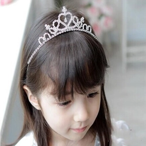 Detail of a child wearing a silver tiara crown with sparkling rhinestones for parties