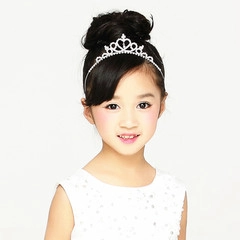 Detailed close-up of a silver children's tiara featuring sparkling rhinestones and heart shapes