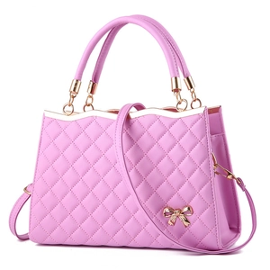 Detail einer rosa gesteppten Handtasche mit goldener Schleife aus Metall