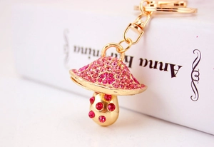Dettaglio del portachiavi a fungo con strass rosa e rossi e moschettone dorato lucido
