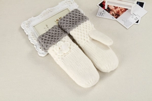 Detail of knitted mittens featuring gray honeycomb wrist texture and plush floral decor