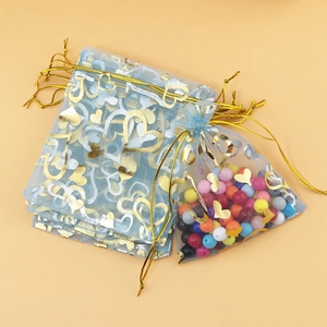 Light blue organza gift bags with gold heart foil print and drawstring closure