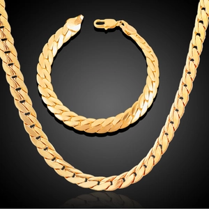 Detailed macro view of 18K gold-plated Figaro chain necklace and bracelet jewelry set