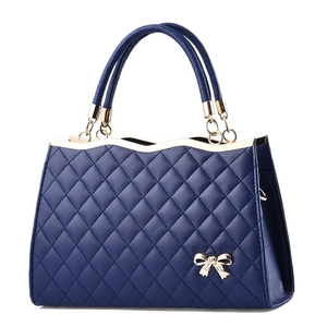 Gesteppte dunkelblaue Damenhandtasche mit goldener Schleife und zwei Tragegriffen