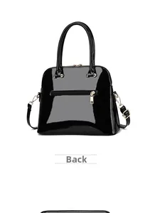 Glossy black patent leather handbag with gold hardware and back zipper pocket detail