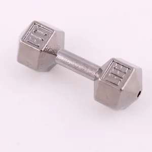 Macro shot of silver dumbbell pendant with FIT engraving on zinc alloy metal surface