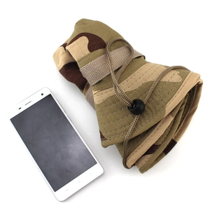 Foldable desert camo boonie hat shown next to a smartphone for compact scale reference