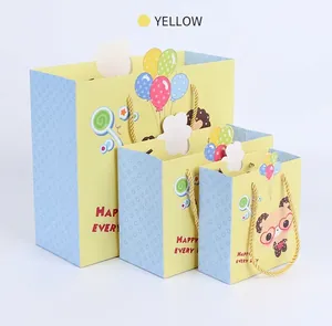 Tre dimensioni di sacchetti regalo panda con manici gialli intrecciati e stampe colorate