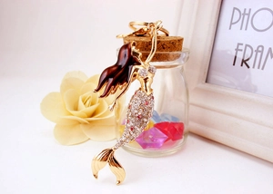 Detail shot of golden mermaid keychain with pink rhinestones and elegant home decor