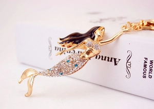 Macro shot of gold mermaid keychain with sparkling rhinestones and blue enamel details