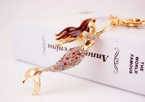 Close-up of golden mermaid keychain with brown hair and sparkling rhinestone scales