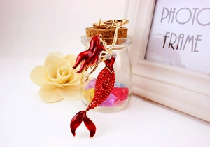 Detail of red rhinestone mermaid keychain with gold metal plating and enamel finish