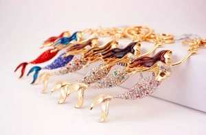Detailed view of colorful rhinestone mermaid keychains with enamel hair and golden ring
