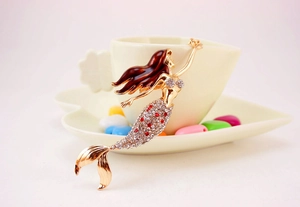 Macro detail of mermaid keychain with golden metal texture and sparkling crystal rhinestones