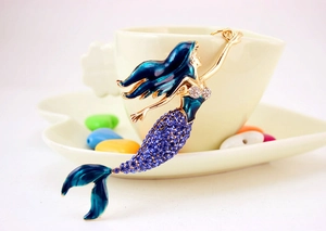 Macro view of crystal mermaid keychain with blue enamel and purple rhinestones detail