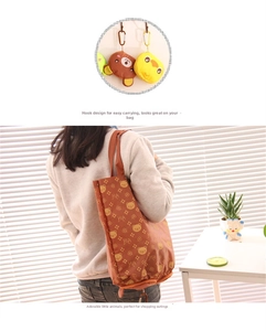 Detail of a foldable shopping bag with brown bear patterns and a hanging hook attachment