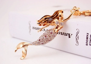 Detail of mermaid keychain with pink rhinestones and gold-tone alloy finish