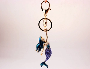 Detailed shot of golden mermaid keychain with purple and blue sparkling rhinestones