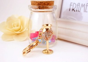 Macro shot of gold wine glass keychain featuring sparkling rhinestones and metal link
