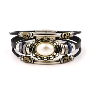 Detail of vintage bohemian multilayer leather bracelet with white pearl and bronze beads
