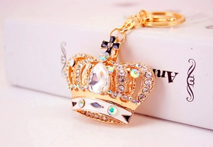 Macro detail of golden crown keychain with sparkling crystals and enamel coating