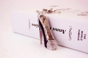 Close-up of black high heel keychain with sparkling crystals on a white background