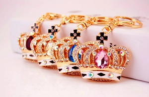 Macro shot of colorful crystal crown keychains in gold finish for handbags