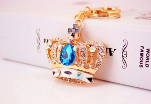 Macro shot of crown keychain with gold metal, blue crystal drop, and clear rhinestones