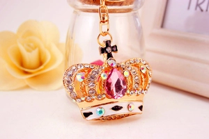 Macro shot of gold alloy crown keychain with pink teardrop gemstone and sparkling crystals