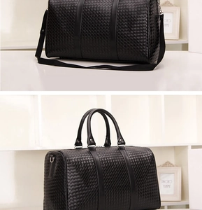 Détail de la texture tissée noire sur grand sac de voyage avec double poignées et sangle