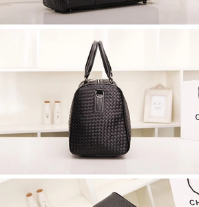 Détail de la texture tressée noire d'un grand sac de voyage avec boucle en métal chromé