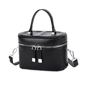 Quilted black cylinder crossbody bag with top handle and silver zipper details