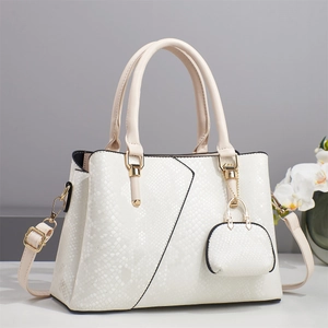 Close-up of white embossed leather tote bag with asymmetric stitching and coin purse