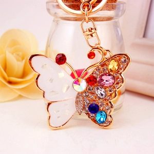 Colorful crystal butterfly keychain with gold plating and rhinestones on blurred background