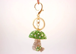 Close-up of sparkling green and clear rhinestone mushroom keychain with gold hardware