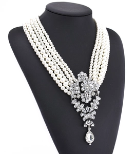 Detail view of multi-layer pearl necklace with a large crystal teardrop pendant on mannequin