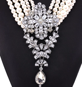 Macro shot of 5-layer pearl necklace with a large crystal cross water drop pendant