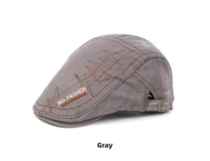 Detail of grey washed cotton flat cap with brown geometric embroidery and metal buckle